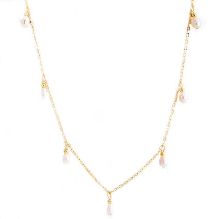 Goudkleurige ketting met hangende pareltjes op wit